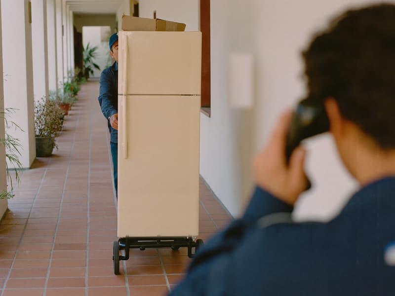 Entrega de una heladera con carretilla en la puerta de un PH.